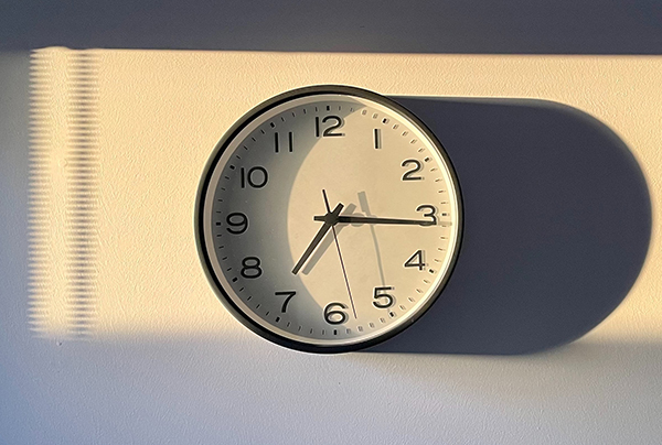 Wall clock showing 7:15 am in the morning sun.